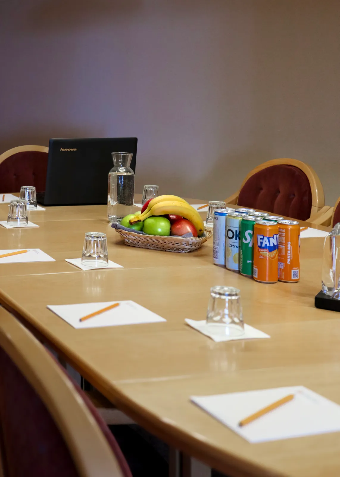Mötesbordet dukat med frukt, anteckningsblock och vatten